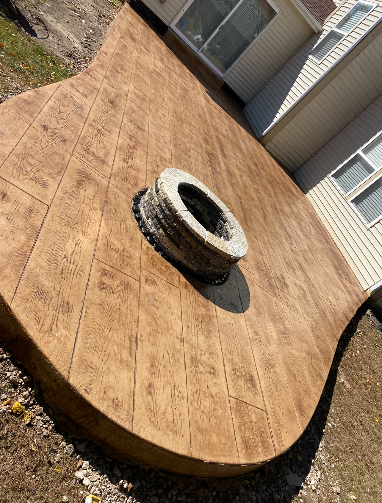 Curved stamped concrete patio with fire pit