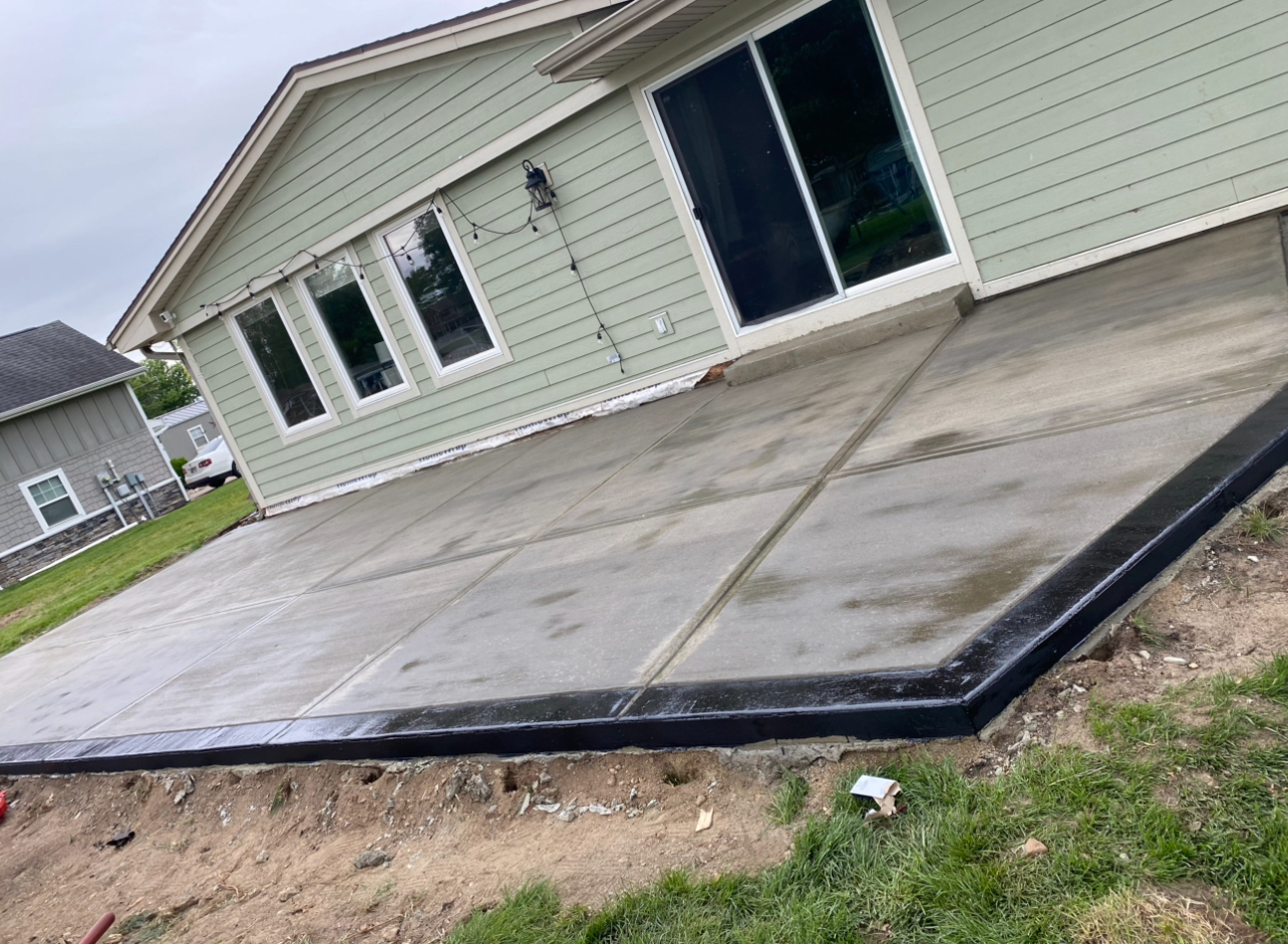 Smooth concrete patio with black stained border